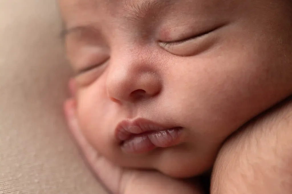 Makrofoto som visar mjuka detaljer i ansiktet hos en nyfödd baby.
