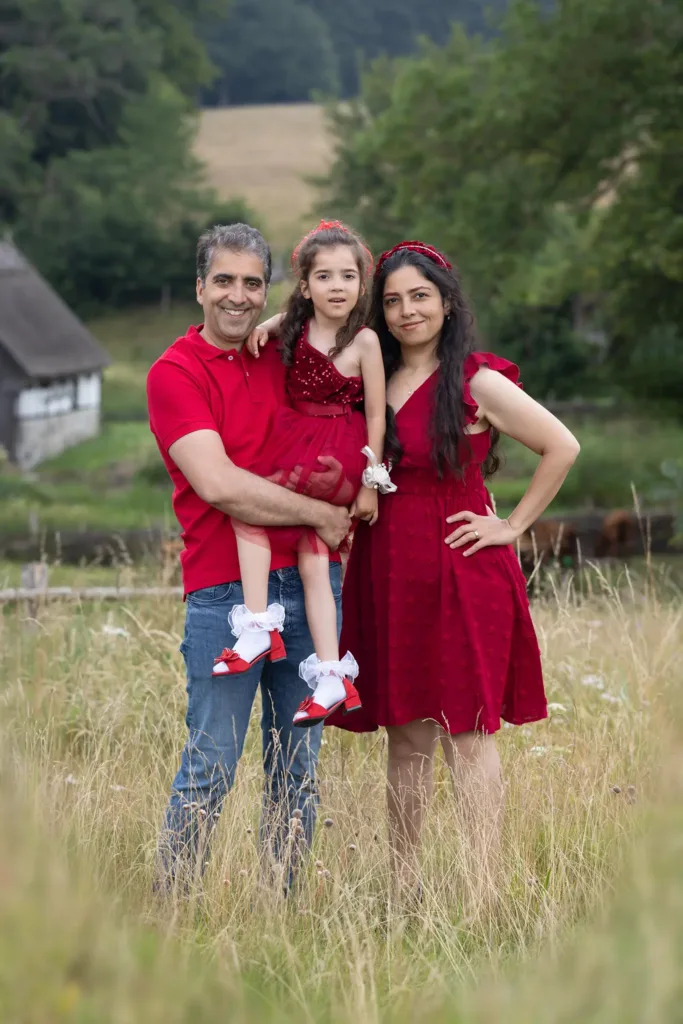 Föräldrar med barn i en äng under familjefoto