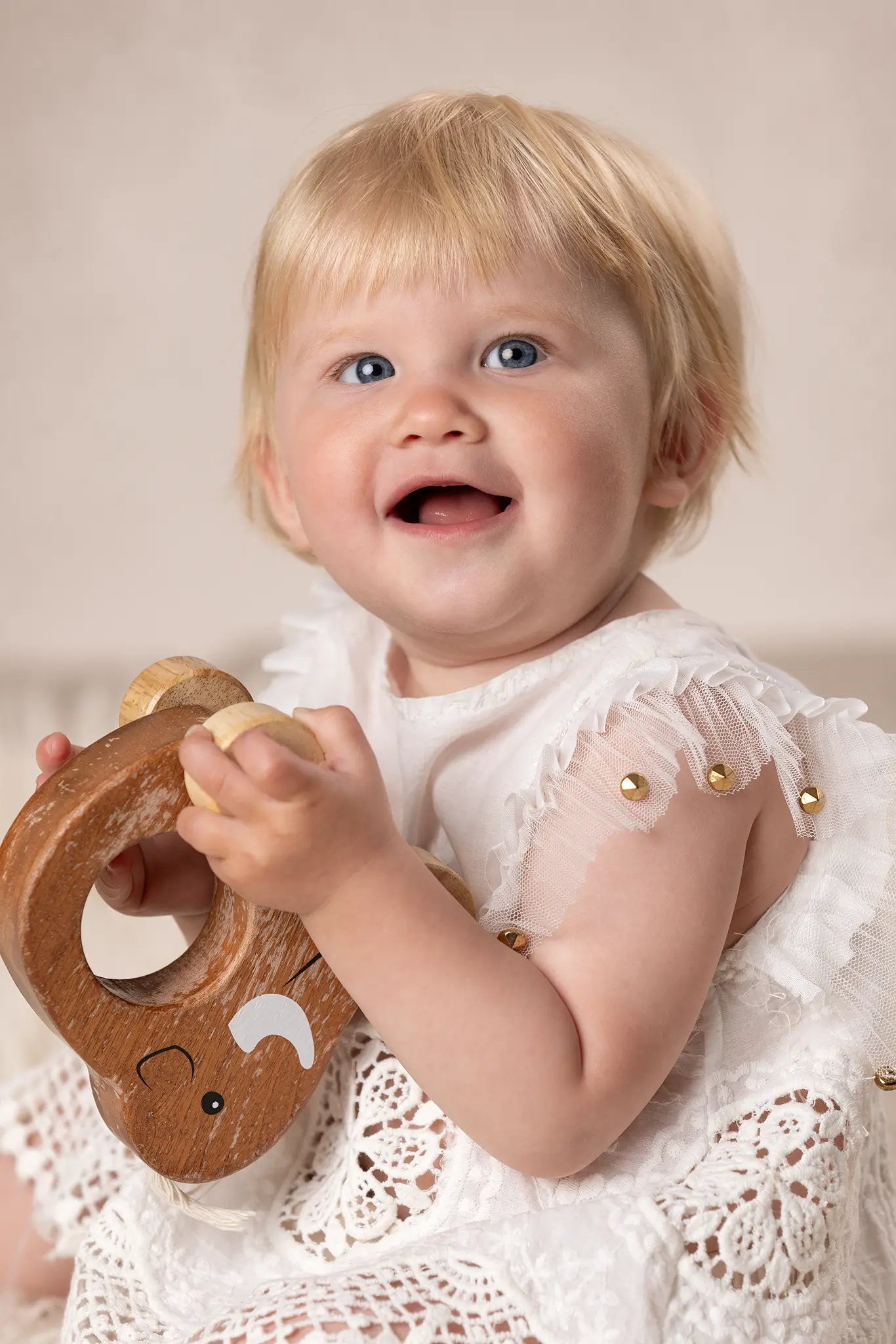 Baby med en träelefant Närbild på bebis som leker med en elefant i trä.