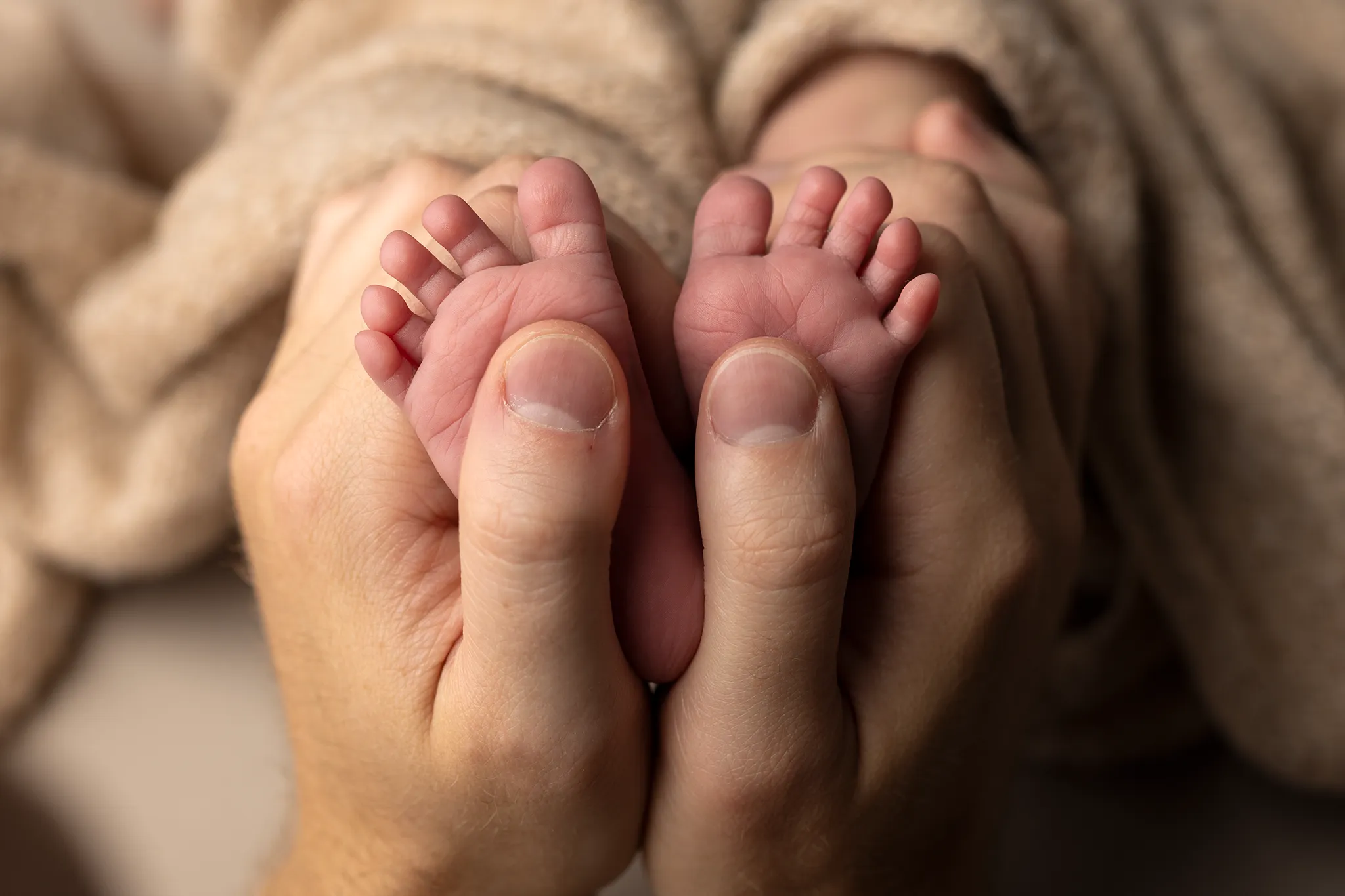 Små söta nyfödd fötter i pappas händer.
