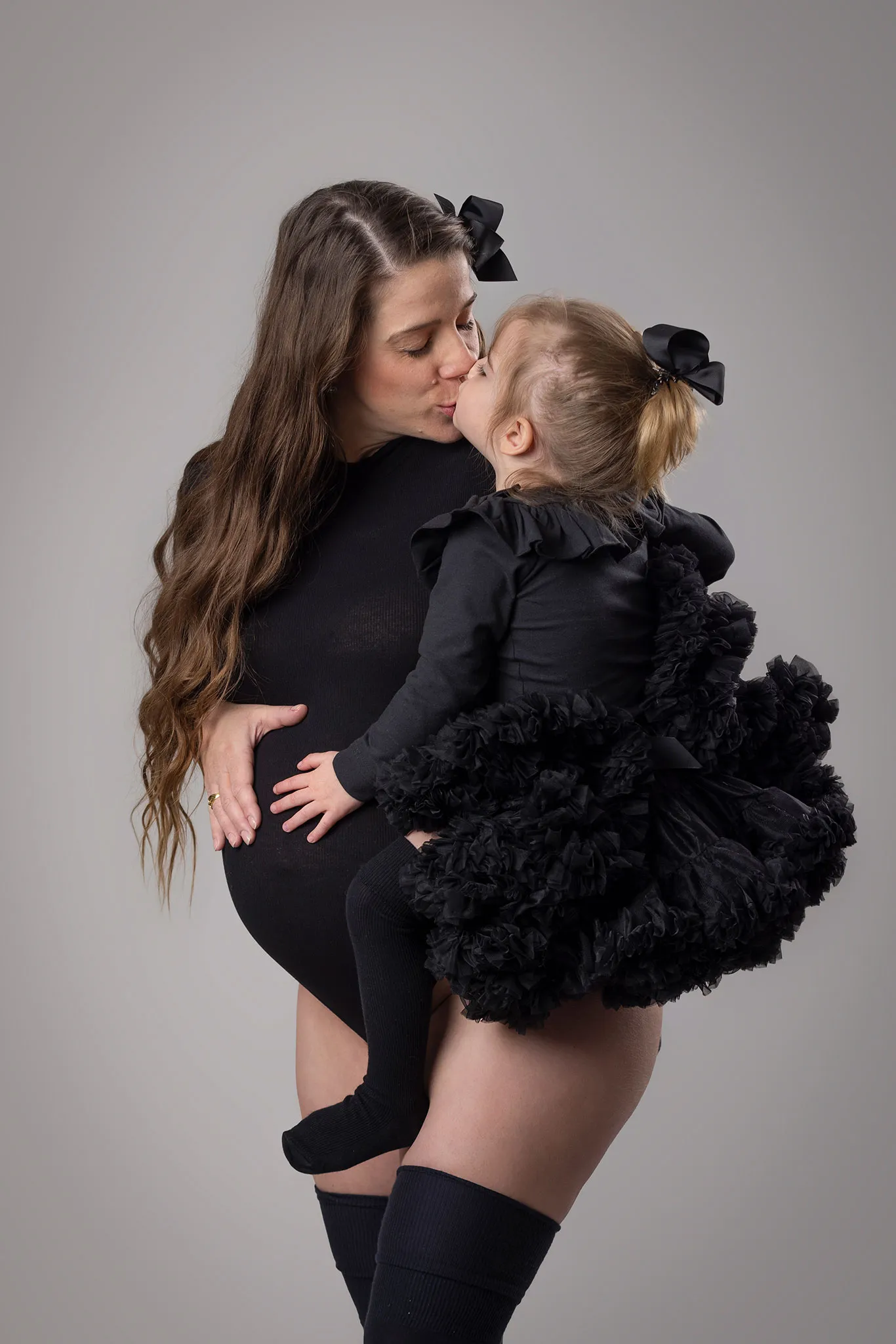 En gravid mamma kramar sitt barn