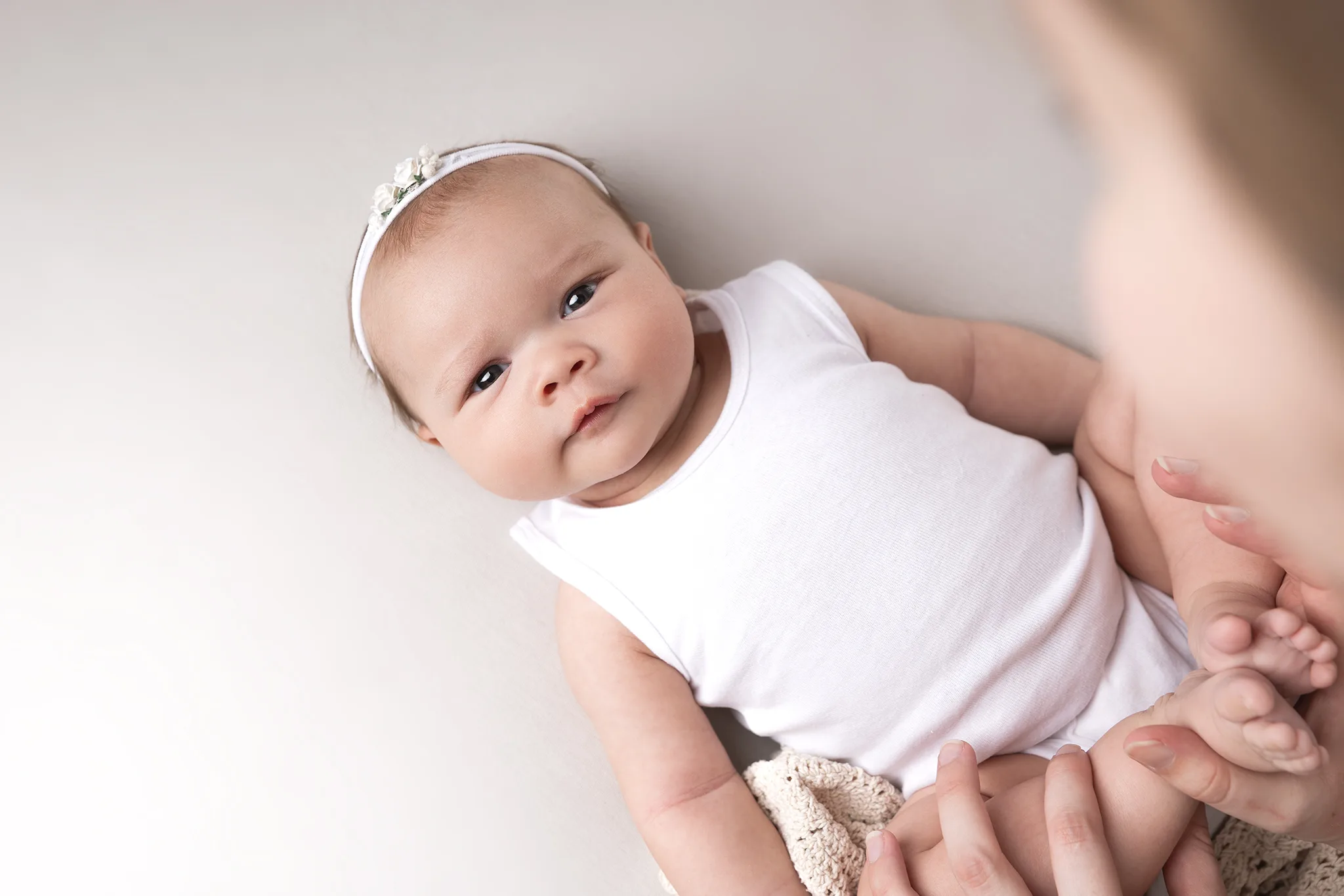 Babyfotografering i Lund av 2 månader gammal bebis med vaket uttryck i ljus studio