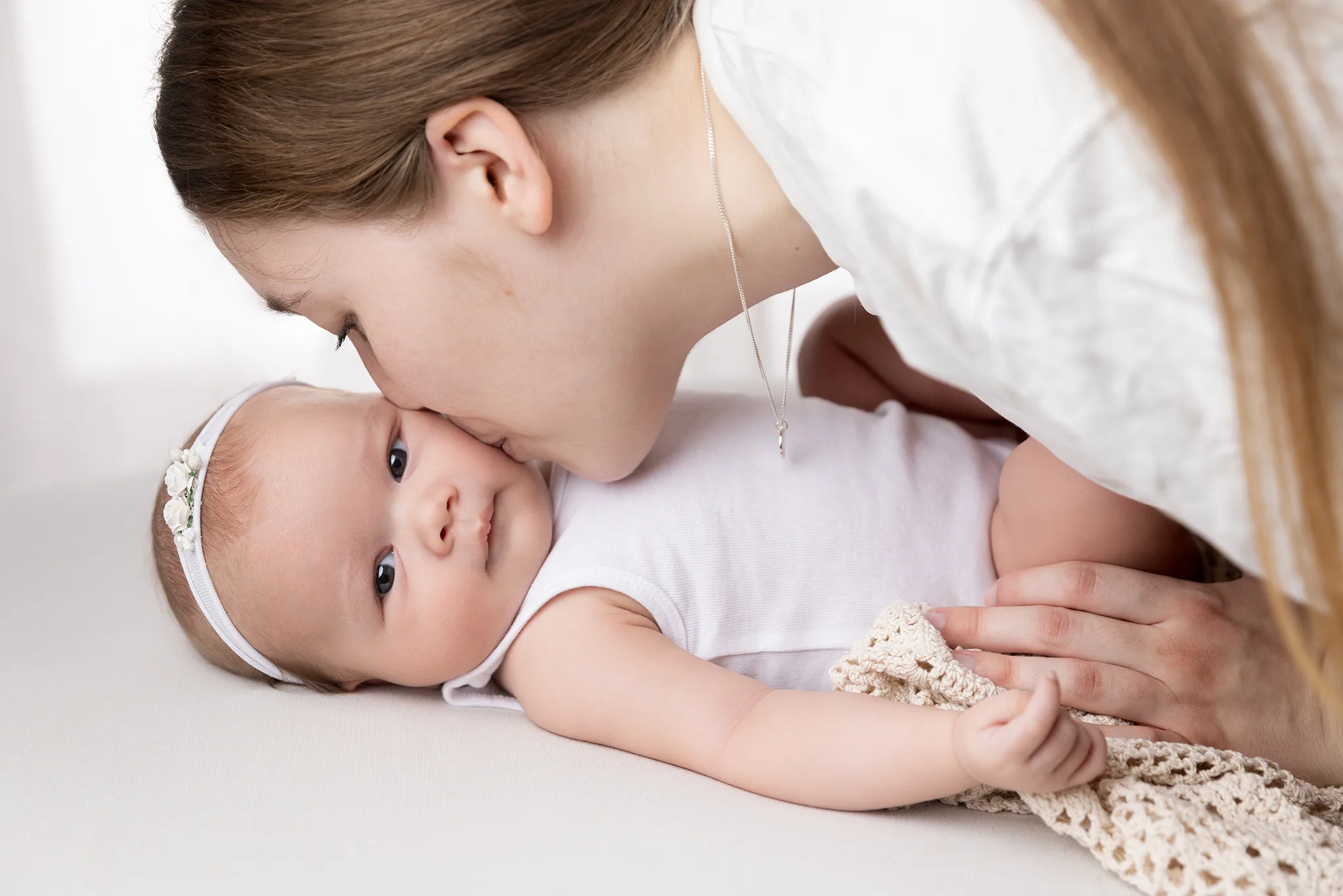 Närhet mellan förälder och 2 månader gammal bebis vid babyfotografering i Lund