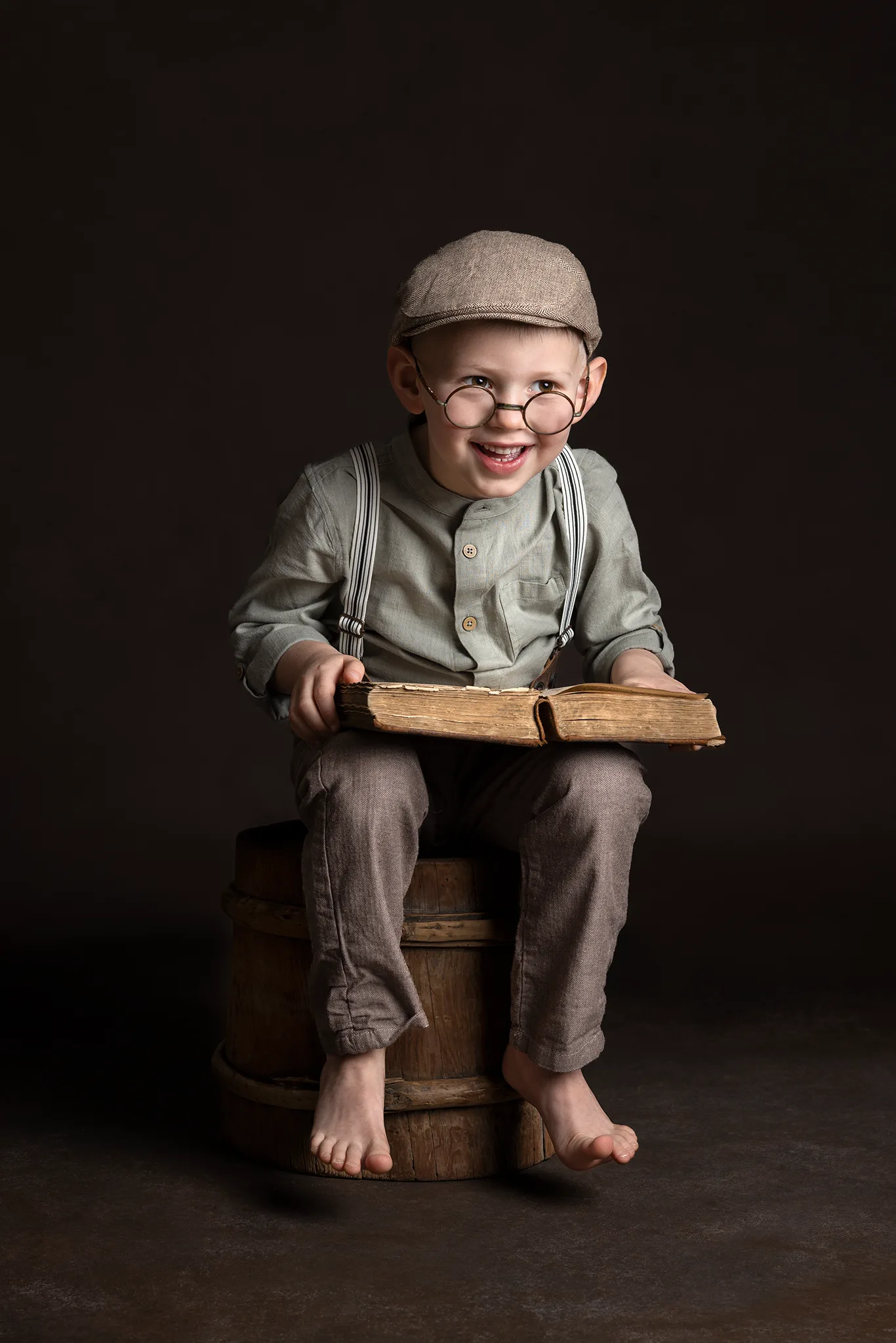 Kreativt barnporträtt av pojke med bok i studio vid barnfotografering i Lund