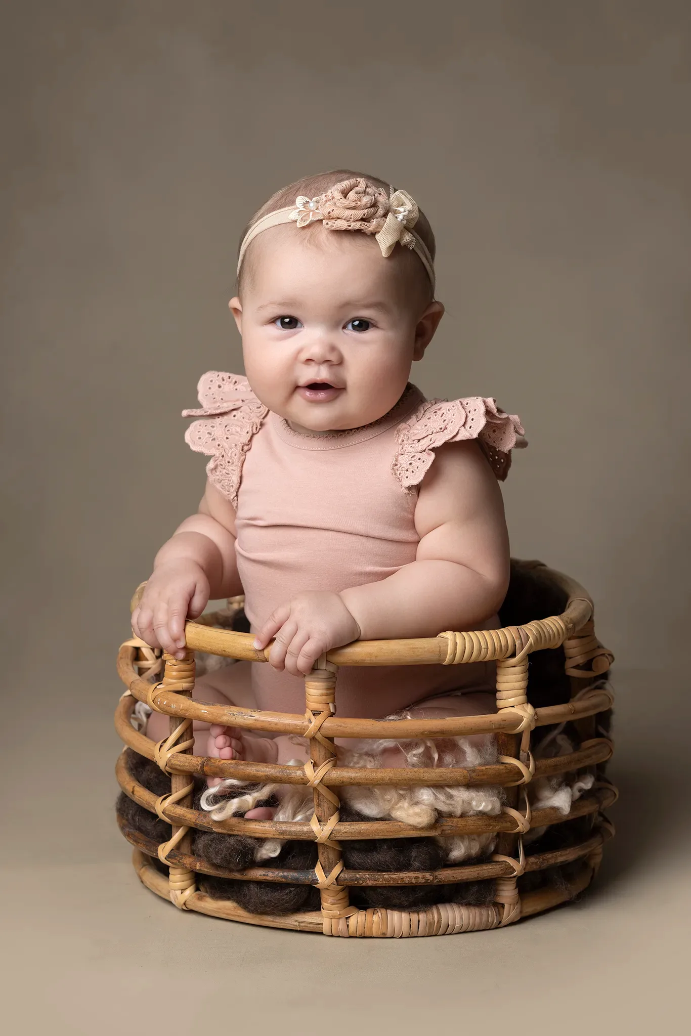 Baby sitter i korg under en babyfotografering i studio hos babyfotograf i Lund