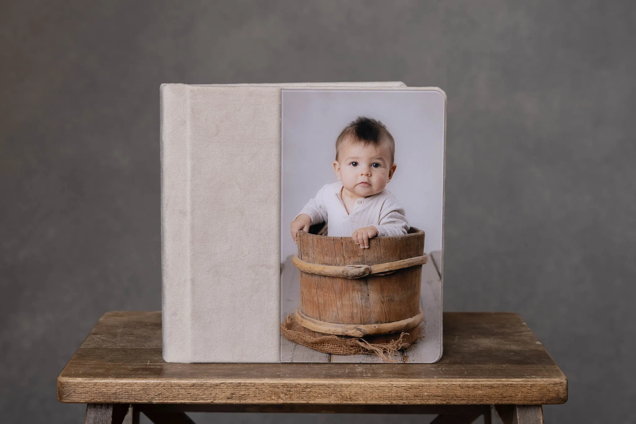 Beige fotoalbum i linne med ett babyporträtt på omslaget